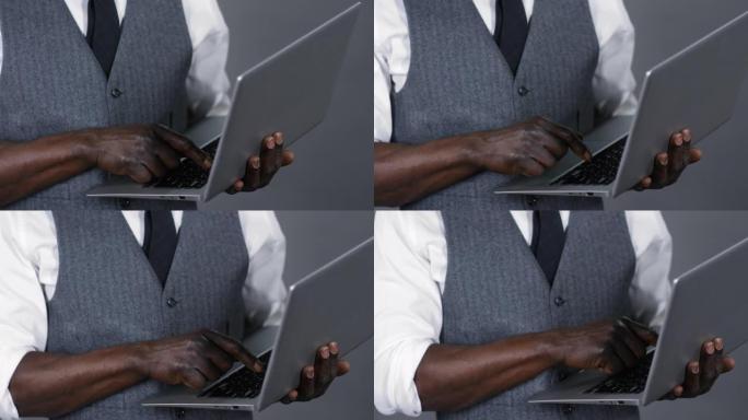 无法识别的非洲绅士使用笔记本电脑