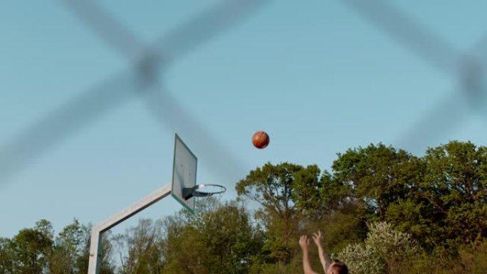 MS超级慢动作男子在室外篮球场上射击篮筐