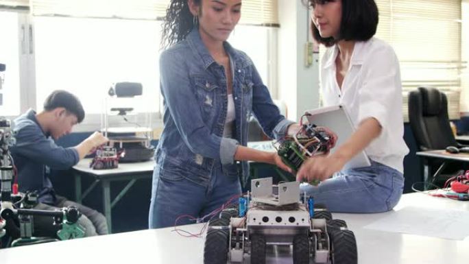 青少年在学校机器人俱乐部项目的全功能可编程机器人上工作。创意设计师在车间测试机器人原型。科学概念。行