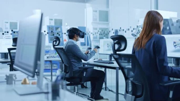 现代工厂: 工业设计工程师佩戴虚拟现实耳机和手持控制器，在计算机上的cad软件中使用VR技术进行工业