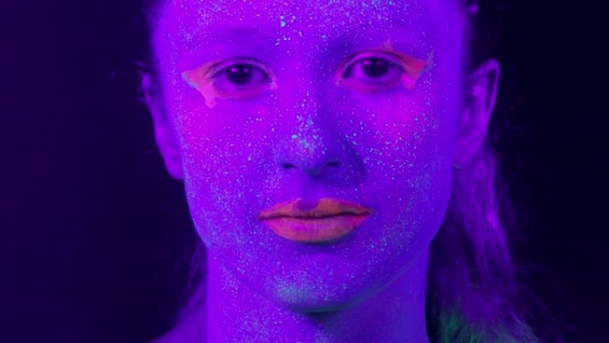 荧光化妆特写女人的脸，创意化妆非常适合夜总会。万圣节派对，表演和音乐概念-慢动作视频