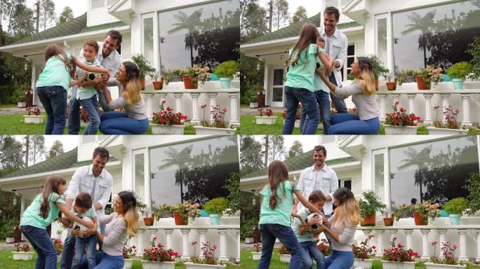拉丁美洲夫妇和他们的两个孩子在后院玩耍，试图抓住足球玩得开心