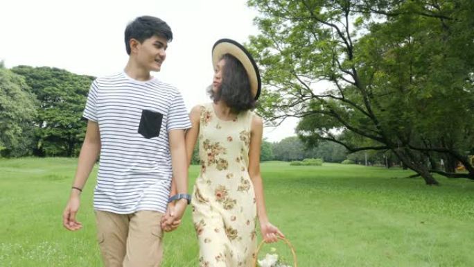 年轻的亚洲夫妇在大自然的春天享受，带着快乐的情感去野餐。有生活方式、爱情观念的人。