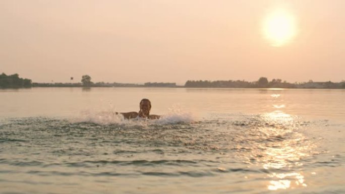 日落时分，狂喜的女人在湖里游泳