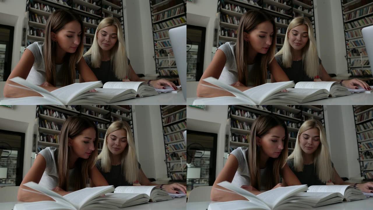 美丽的朋友在图书馆一起学习，一个注意，另一个大声朗读