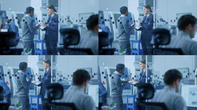 现代工厂: 女项目经理男工程师站在高科技开发设施中，交谈和使用平板电脑。拥有数控机械、机械臂生产线的