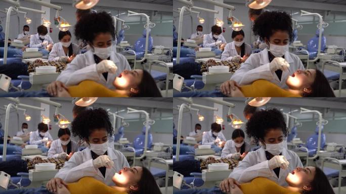 年轻的黑人女牙医学生在课堂上检查病人