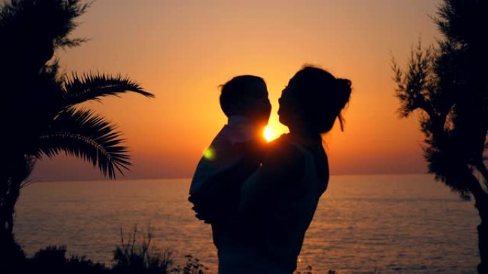 日落海与一个女人亲吻一个孩子