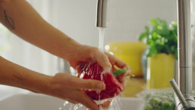 特写一个人用自来水洗红甜椒的镜头。正宗的时尚厨房配健康蔬菜。来自有机农业和绿色饮食概念的天然清洁产品