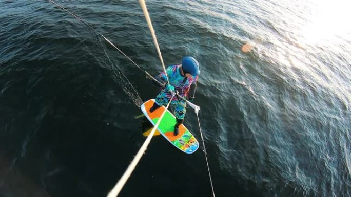 一名穿着泳装的男子正在骑风筝冲浪板