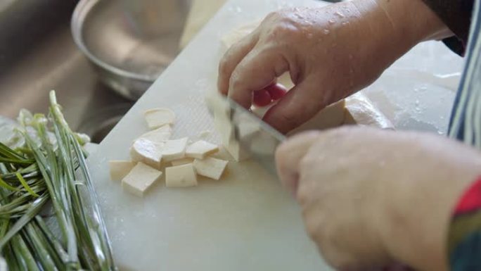 亚洲妇女在厨房手工切豆腐