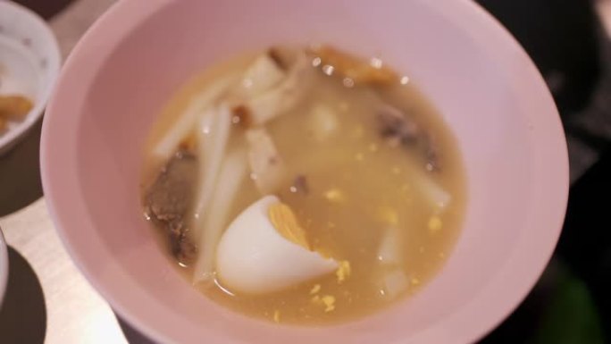 在街头美食中吃中国卷面汤和脆皮猪肉 (Kuay Jab)