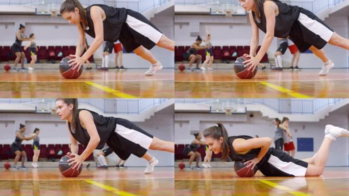 年轻女孩在球场上锻炼时用篮球俯卧撑