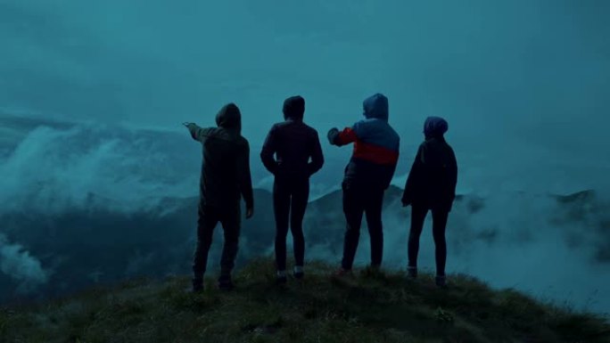 四个人站在风景如画的晚山上