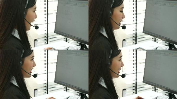 在呼叫中心工作的年轻亚洲女性使用耳机与客户交谈