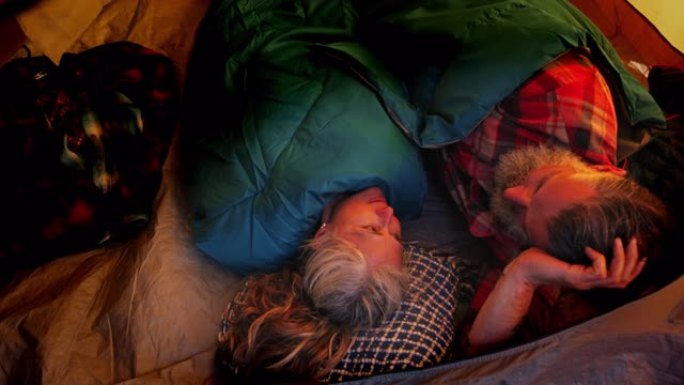 关闭高级夫妇躺在森林的帐篷里