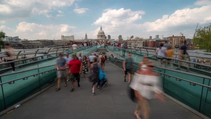 延时: 英国伦敦的圣保罗大教堂在千禧桥上的人行通勤人群