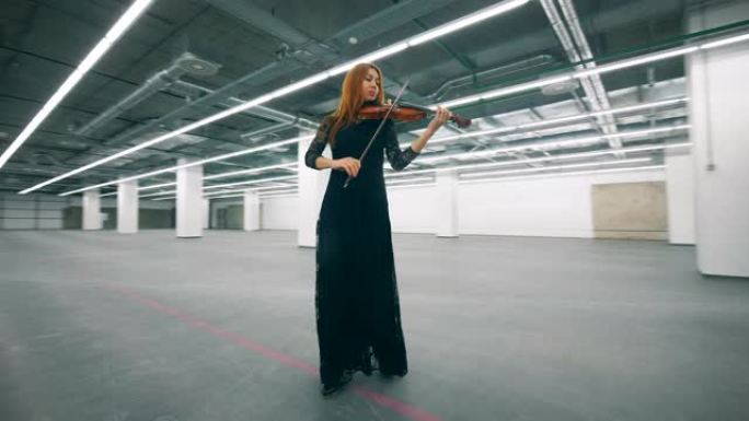 空荡荡的大厅和一个女人边走边拉小提琴