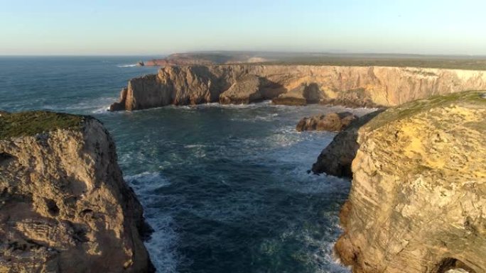 在葡萄牙圣文森特角 (Cabo de Sao Vicente) 飞越挥舞着大西洋和覆盖着绿色苔藓的黄