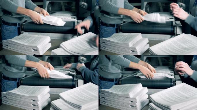 员工正在堆放折叠的打印纸