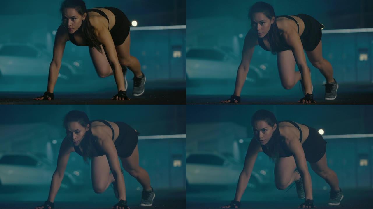穿着黑色运动上衣和短裤的美丽精力充沛的健身女孩正在做登山运动。她正在傍晚的城市环境中进行锻炼，背景是