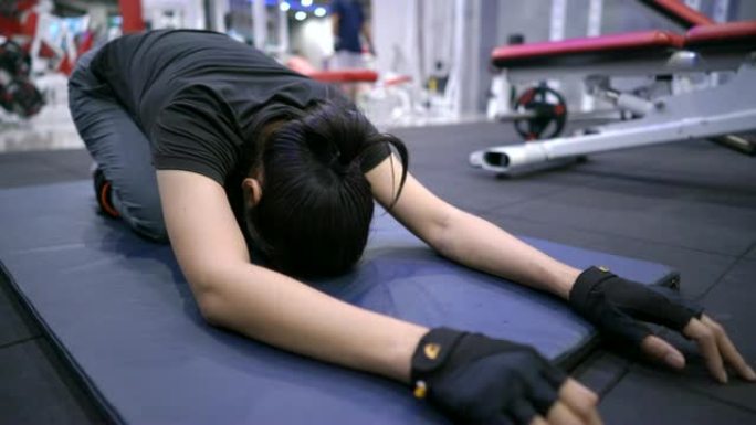 女性在健身房做瑜伽伸展运动。