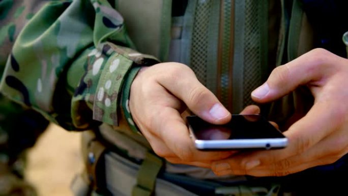 军事训练中使用手机的高加索军事士兵的中段4k