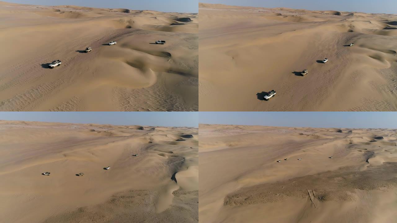 4x4车辆沿着纳米比亚纳米布沙漠骨架海岸风景如画的沙丘行驶的4k鸟瞰图
