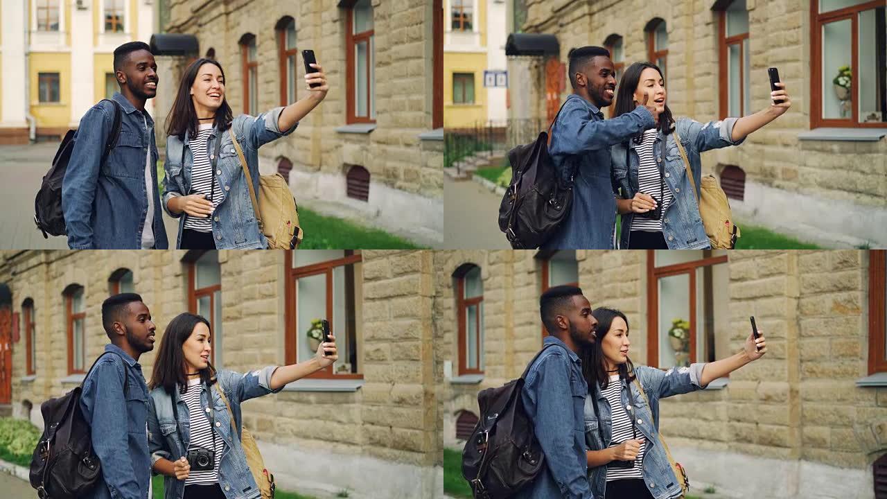 兴奋的游客男人和女人正在用智能手机手持设备进行在线视频通话，并交谈表示竖起大拇指，表达积极的情绪。