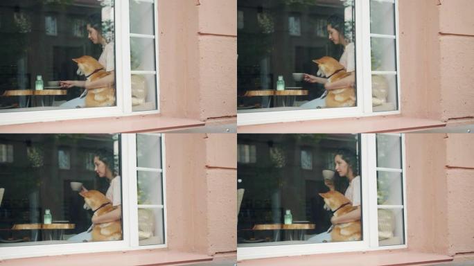 美女在咖啡馆喝茶拥抱可爱的柴犬