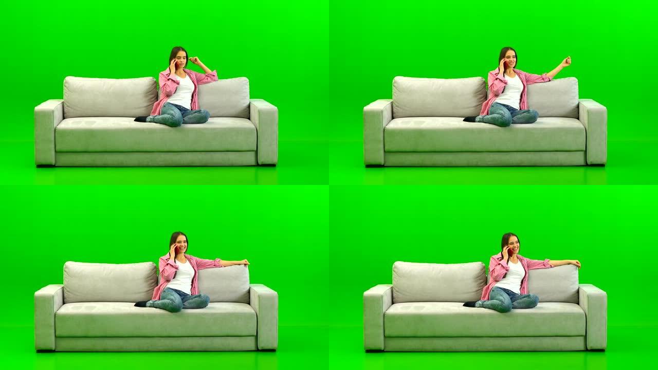 绿色背景沙发上的女人电话