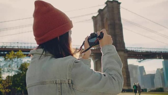 亚洲女性游客使用数码相机拍摄河流全景照片