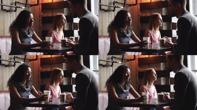 非洲妇女和白人男子的朋友在咖啡馆的桌子上聊天