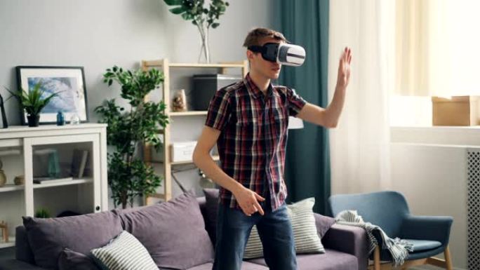年轻人有虚拟现实眼镜的经验，站在家里动手。