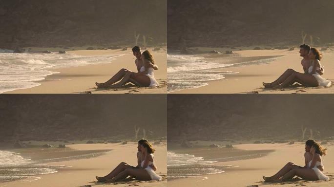 一个年轻的男孩和一个女孩坐在海边的沙滩上，恋人在日落时看着海浪，大海的背景。