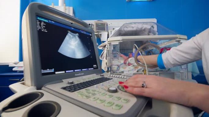 女儿科医生使用筛选机检查婴儿的心脏。