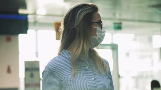 戴着医用口罩和眼镜的妇女通过玻璃拍摄。冠状病毒、流行病、感染概念。