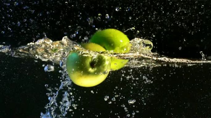 新鲜的苹果慢慢落入水中，健康的零食，维生素的来源。