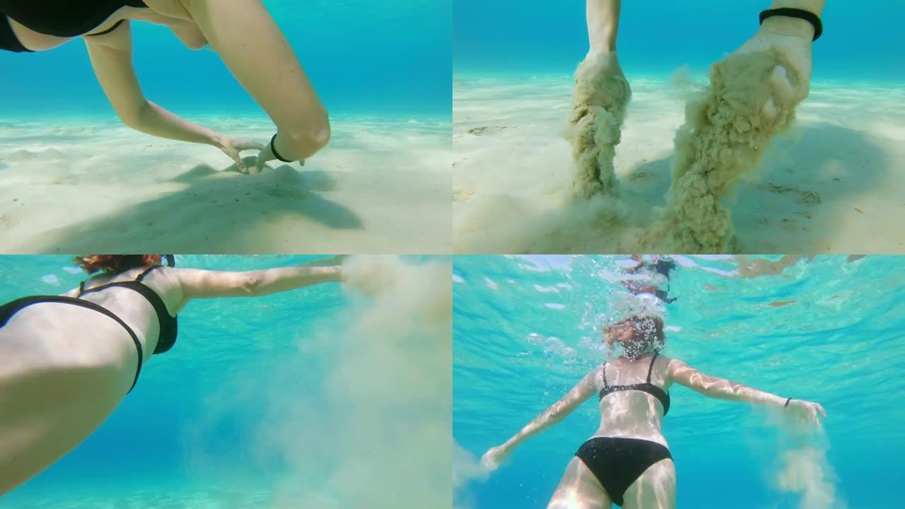 女士在水下浮潜，在碧蓝的海洋中抓住少量沙子
