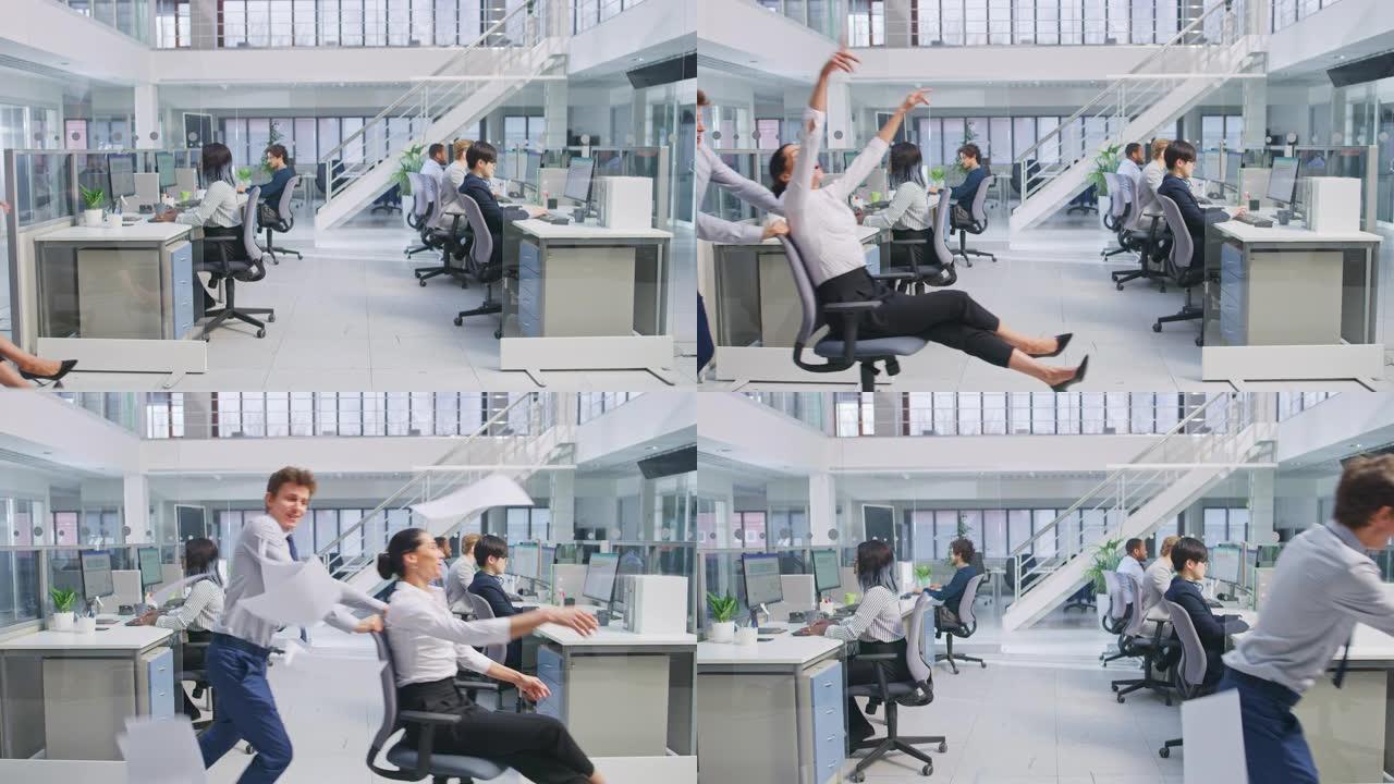开朗的员工将他美丽的同事推到椅子上，旁边是在现代办公空间中从事计算机工作的各种商务人士。女性在空中抛