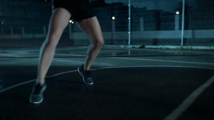 一个美丽的精力充沛的健身女孩做步法跑步训练的特写镜头。她正在一个有围栏的室外篮球场里锻炼身体。居民区