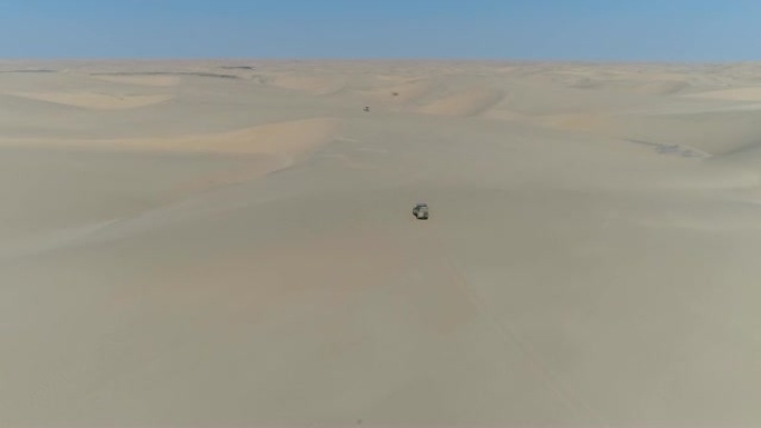 4k空中飞越纳米比亚纳米布沙漠骨架海岸沙丘上行驶的4x4车辆