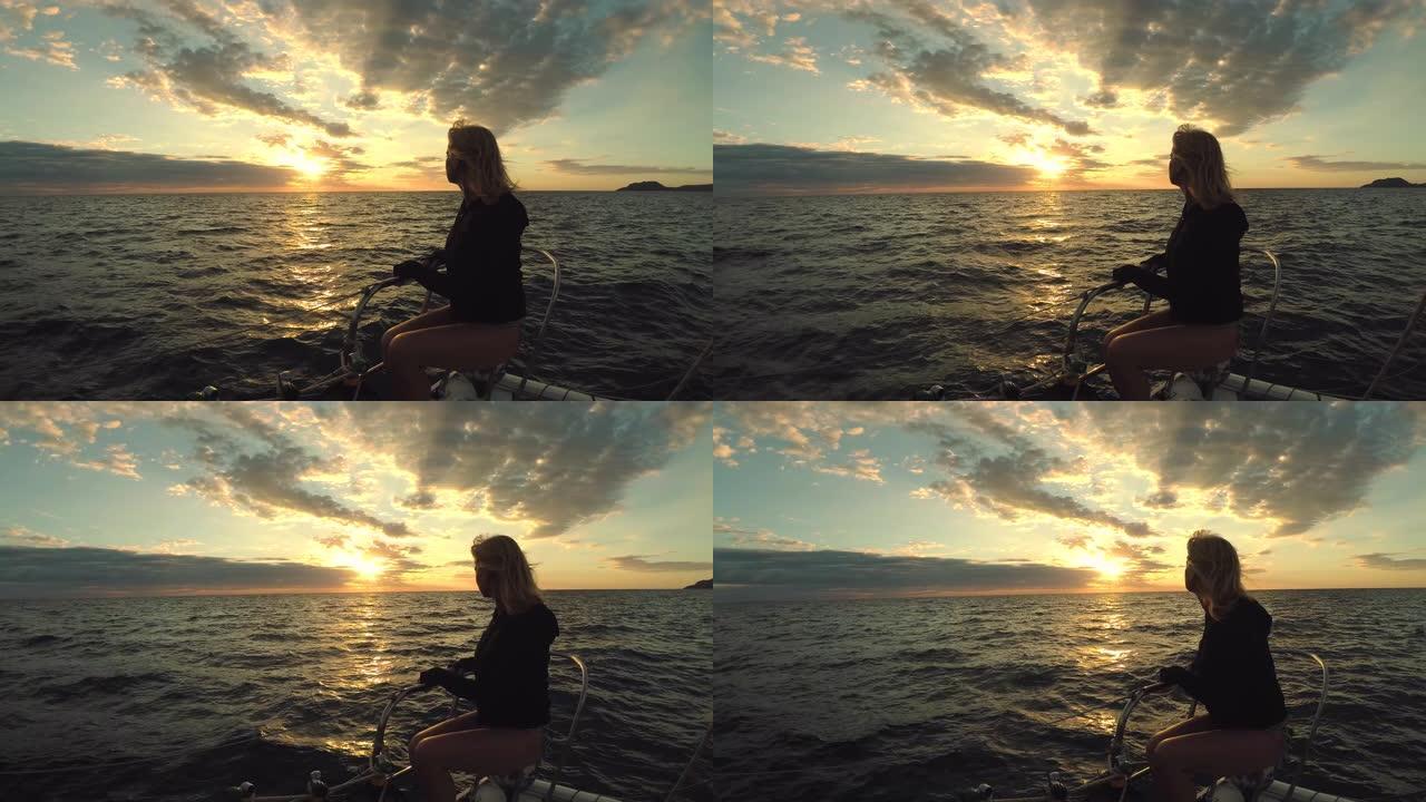 海中船尖上的一位女士观看日落并放松身心。