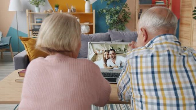 退休夫妇在家里与年轻人家庭进行在线视频通话