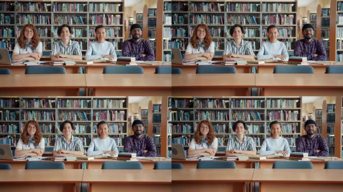 多种族的年轻人学生坐在图书馆的办公桌前微笑