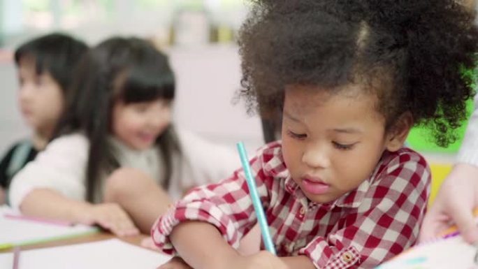 慢动作-一群孩子在教室里画画，多民族的年轻男孩和女孩在小学快乐有趣的学习和在纸上画画。孩子们在学校画