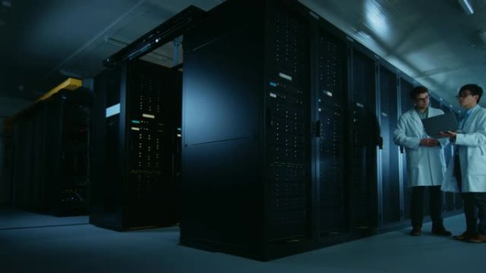 在数据中心: 两名穿着白大褂的IT专家讨论了服务器机架的工作。数据库优化工作。云计算、人工智能联网