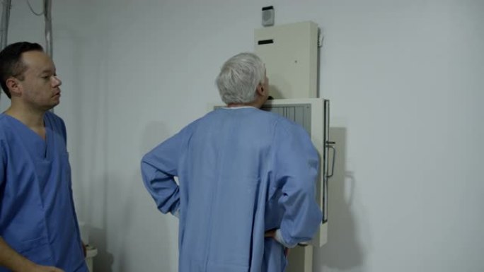 男性放射科医生为高级患者准备进行胸部x射线检查