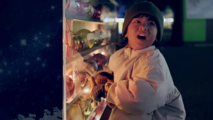 亚洲小男孩站在装饰好的圣诞树旁寻找礼物。
