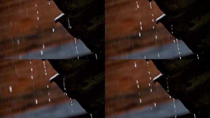 热带降雨时水流下来。水滴从房子的黑暗屋顶上掉下来。慢动作镜头